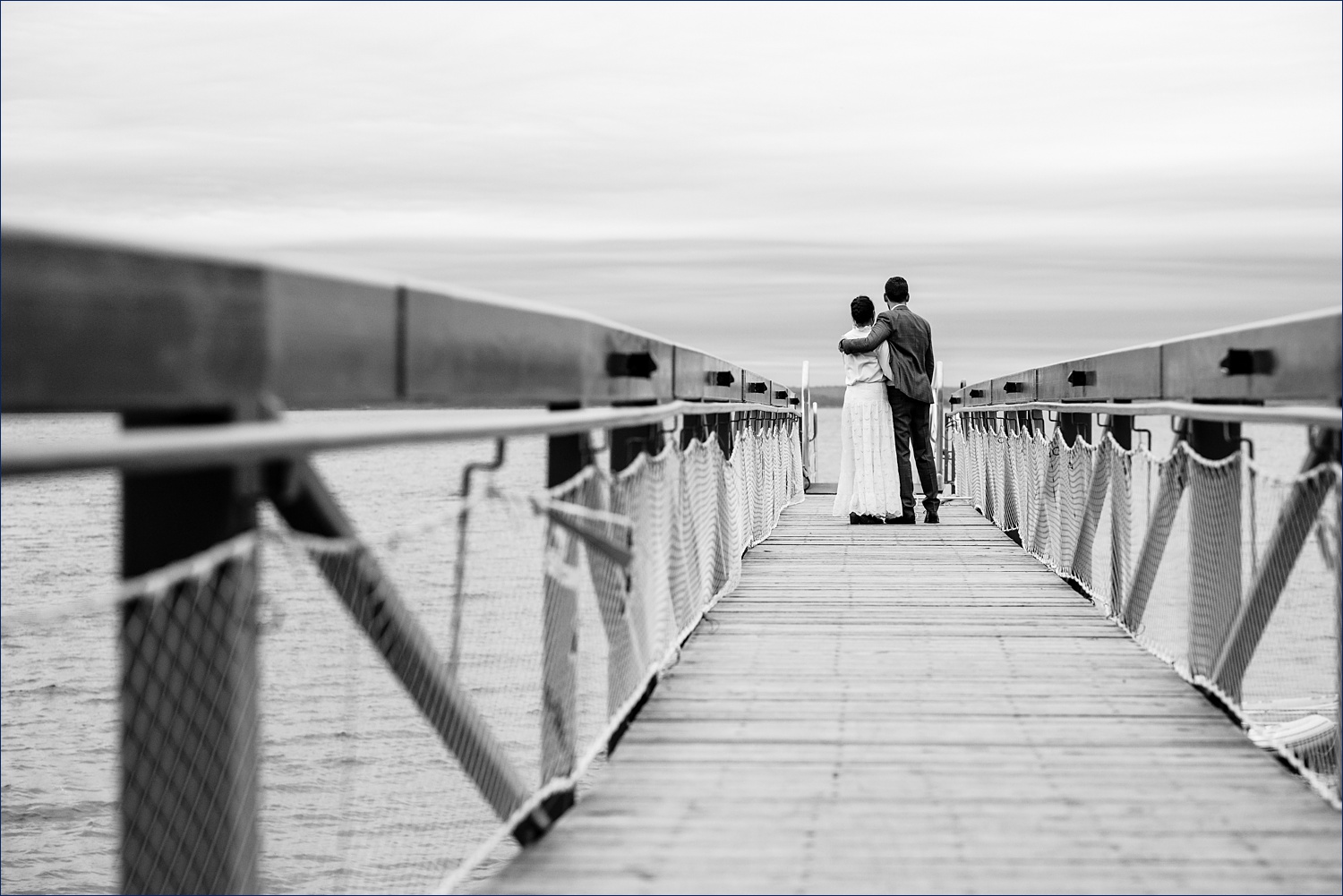 Married couple walks down the dock at College of the Atlantic Maine