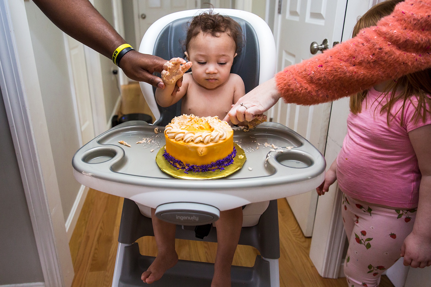 Smashing the cake with a little help from his parents