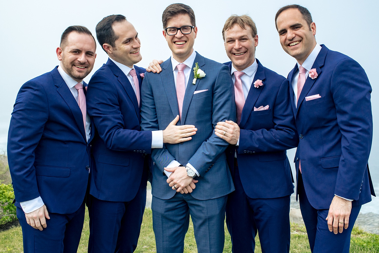 The groom and the groomsmen share a moment on the hazy wedding day