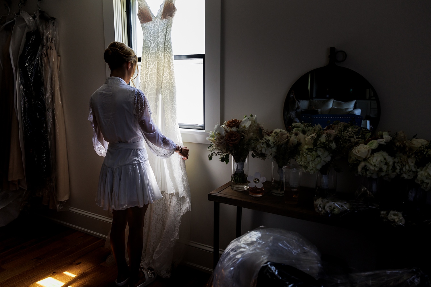 The bride gazes at her wedding gown on her Cunningham Farm Maine wedding day