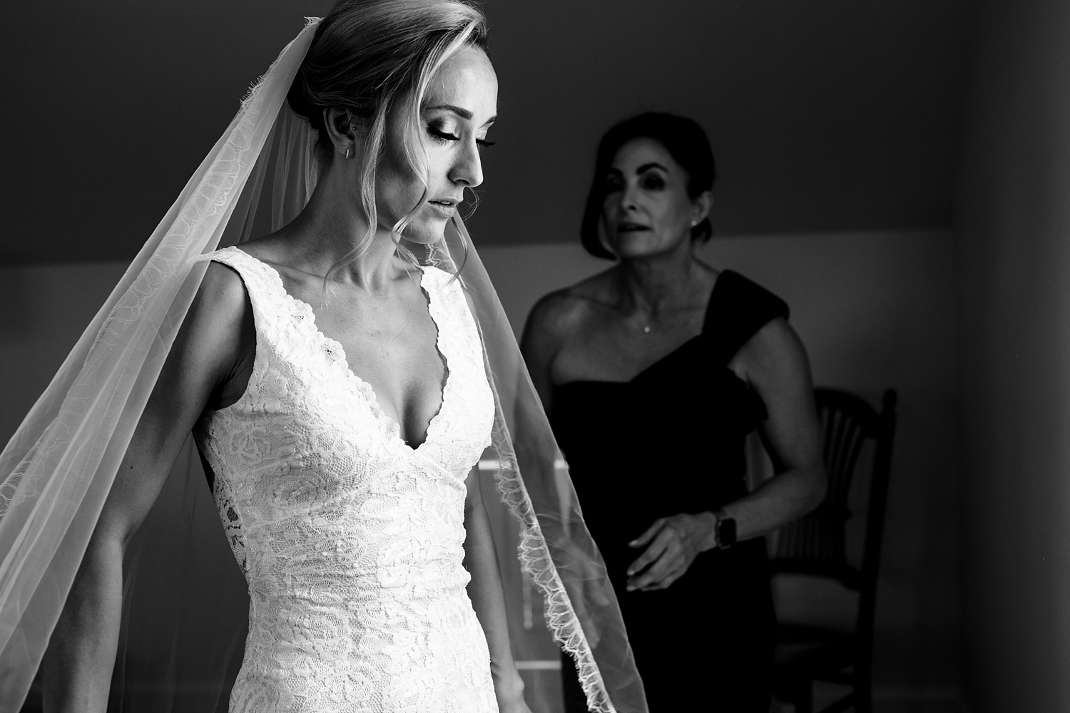 The bride and her mom get her into her wedding gown in maine