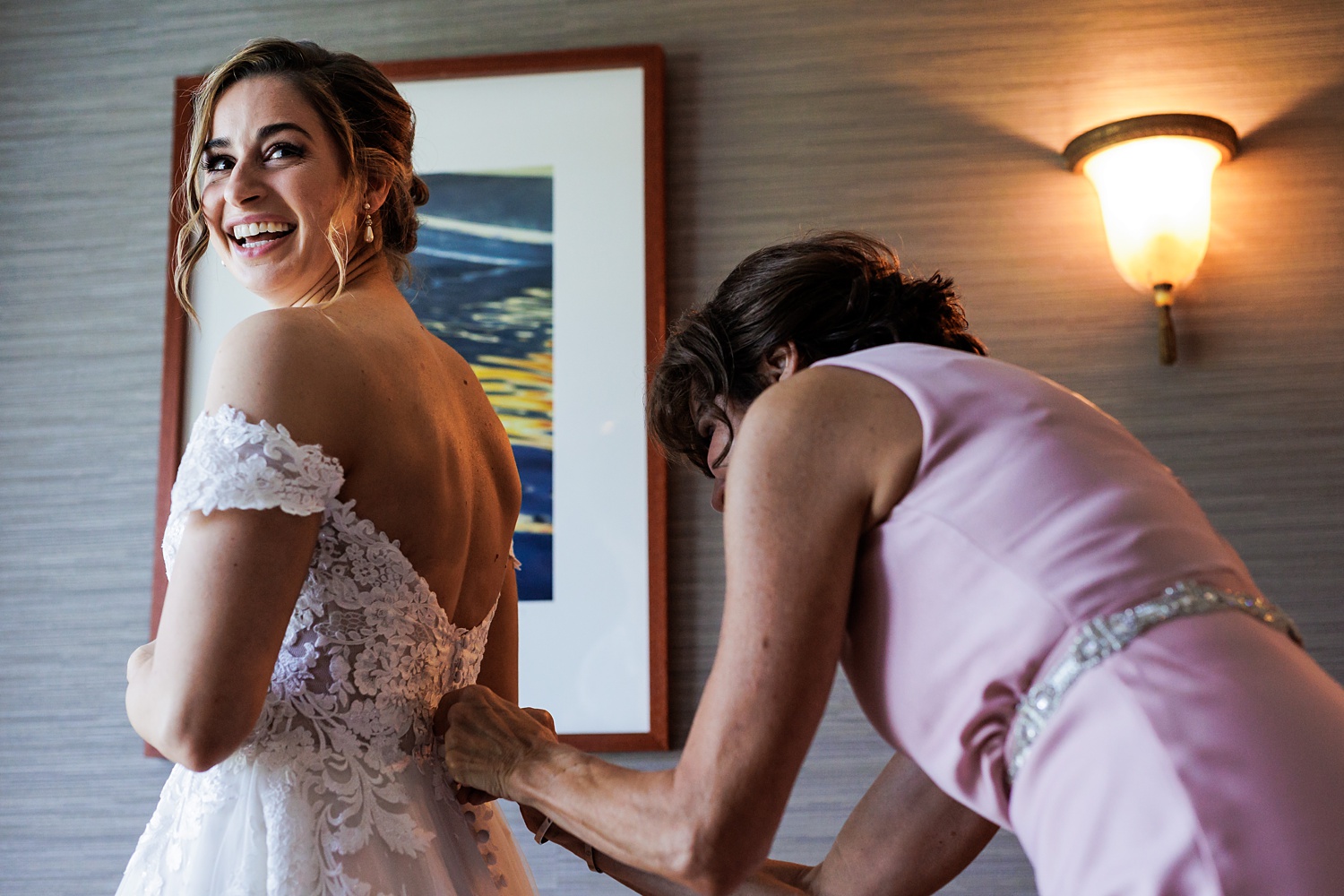 The bride gets into her wedding attire with her mom
