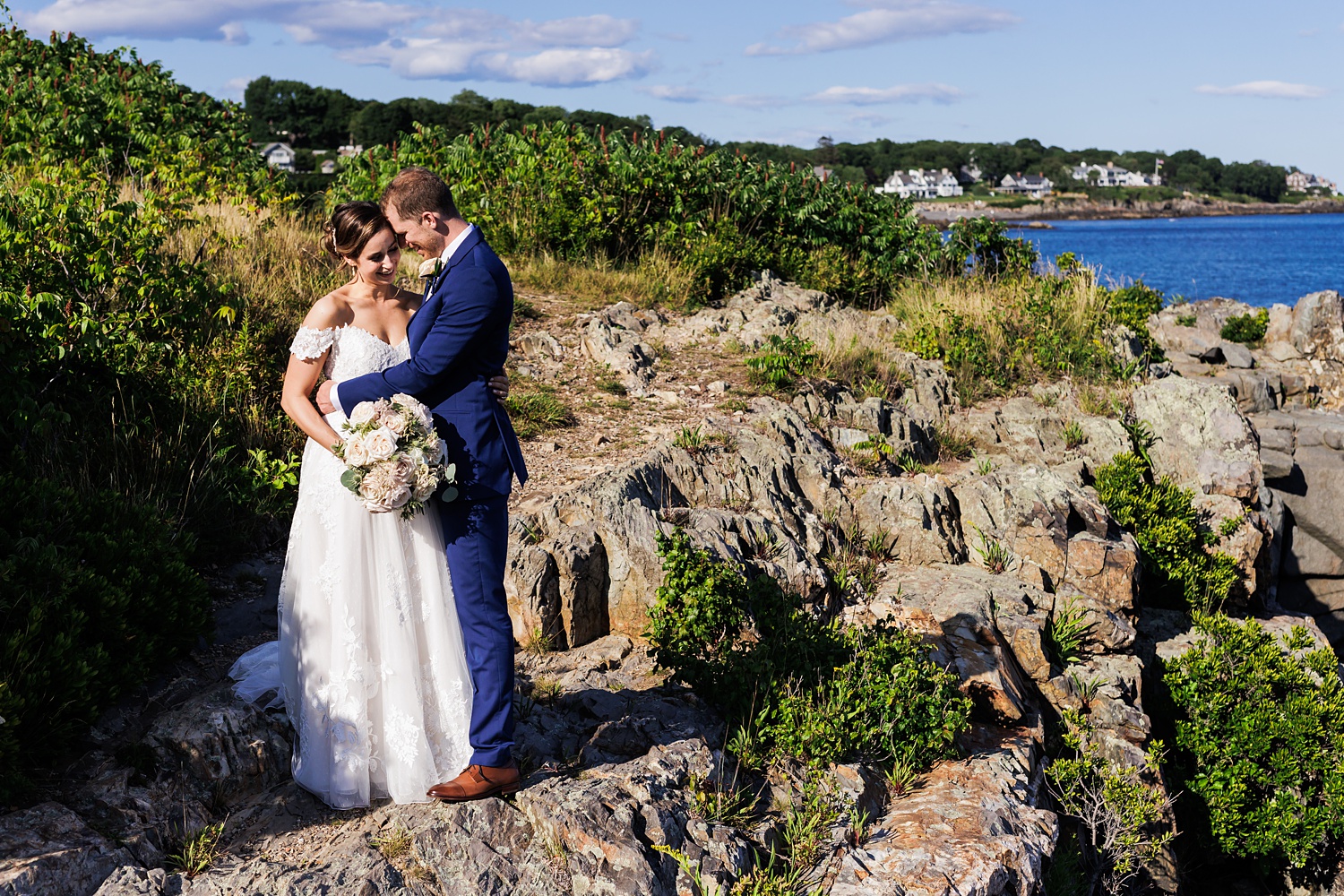The bride and groom get close on the rocks at Stageneck Inn in Maine