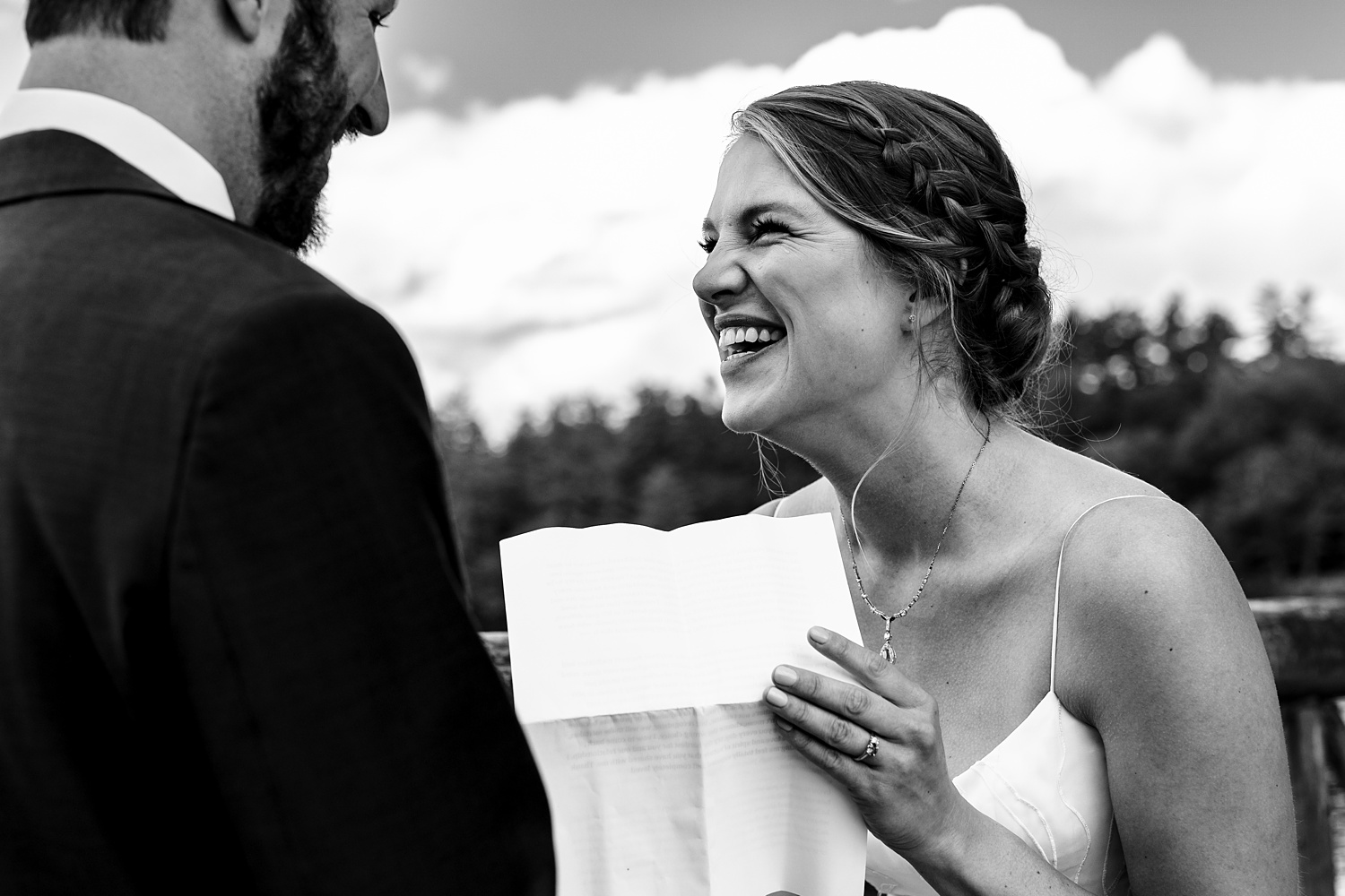 Bride laughs as she reads her vows to the groom on her wedding day