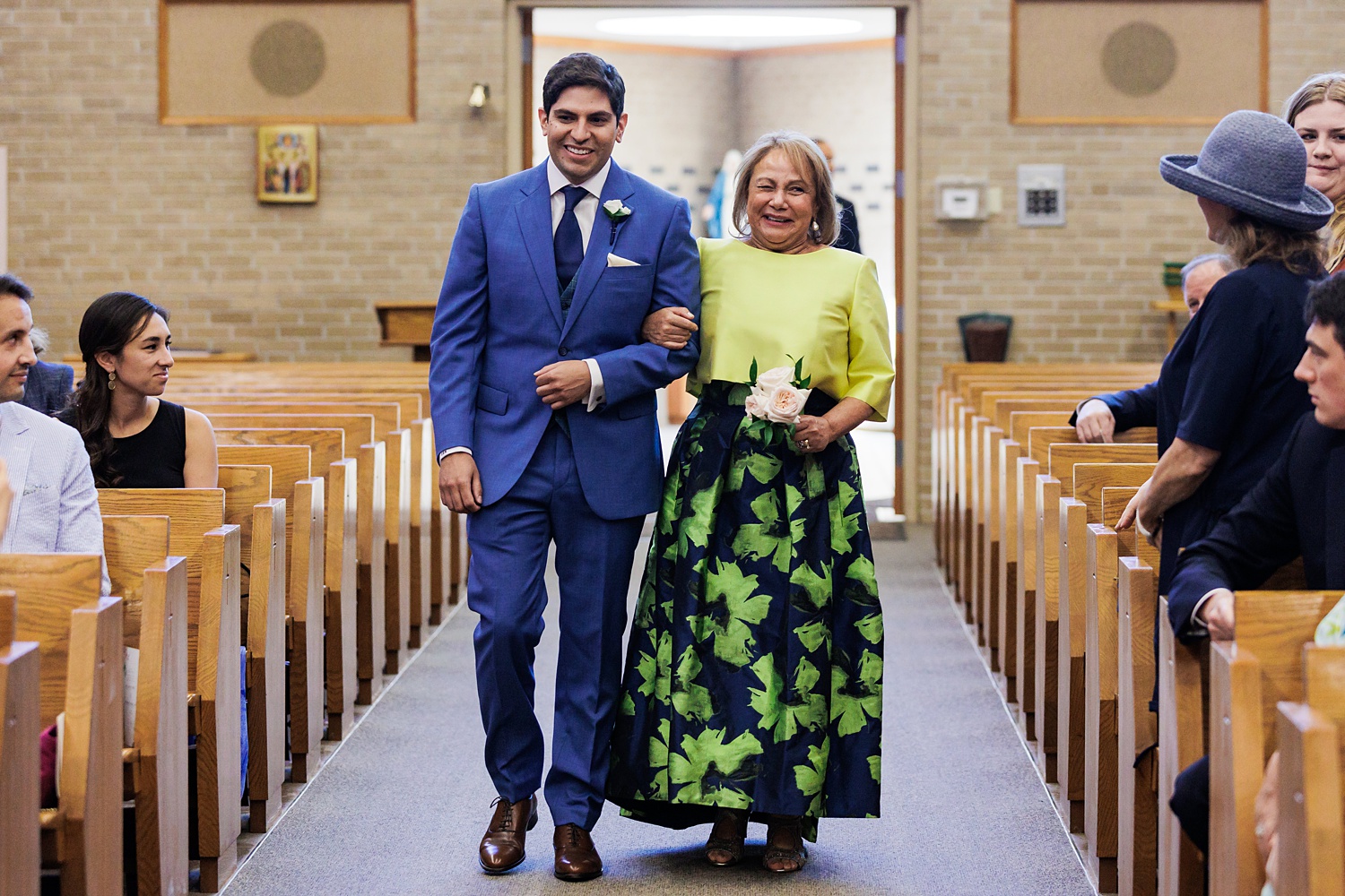 The groom and his mom come down the wedding aisle