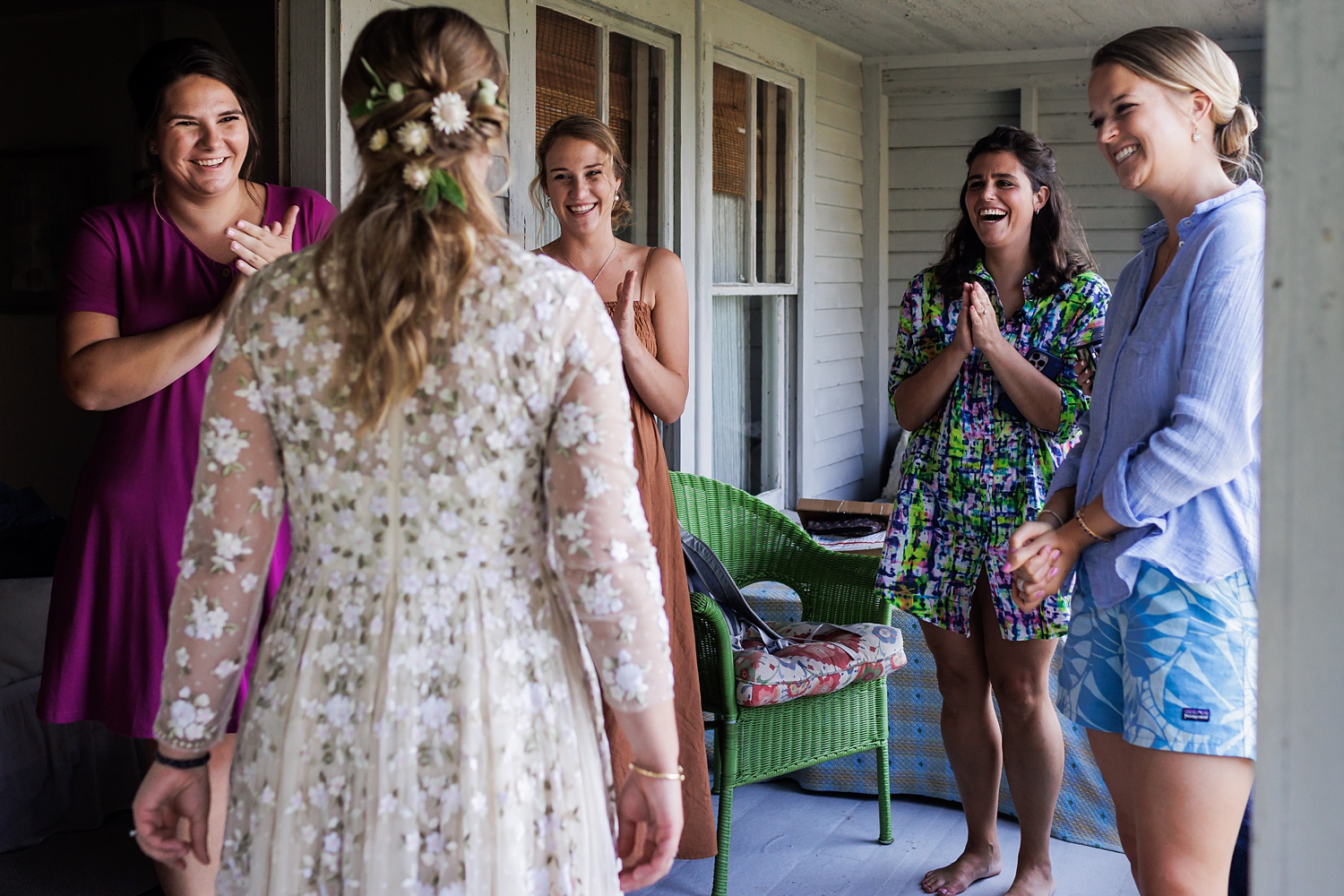 The bride's friends get excited to see their friend ready for the wedding day