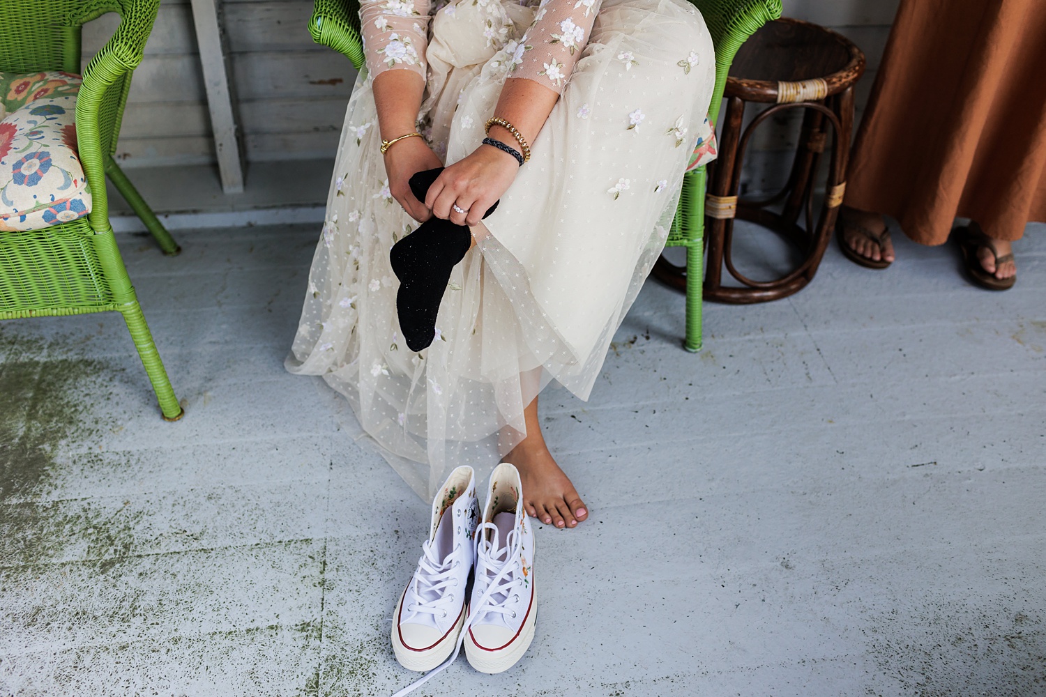 Bride puts on her customized Converse as her wedding day shoes