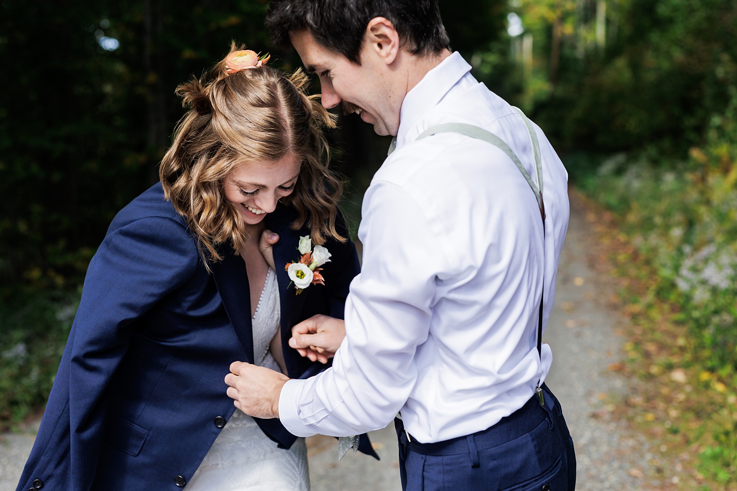 The groom wraps the bride up in his suit coat on the chilly fall day