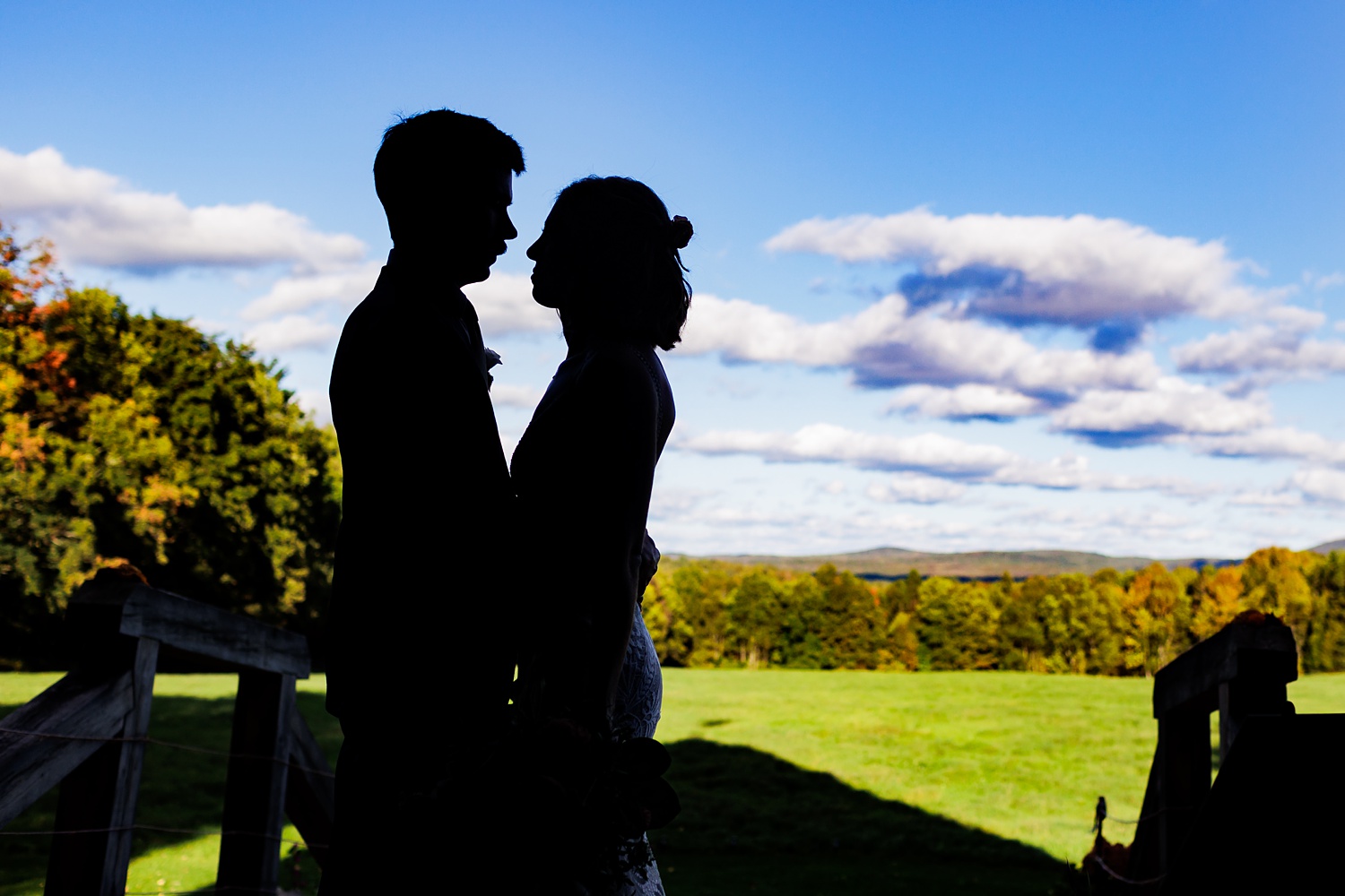 Silhouette from inside the barn overlooking the mountains and sunny wedding day