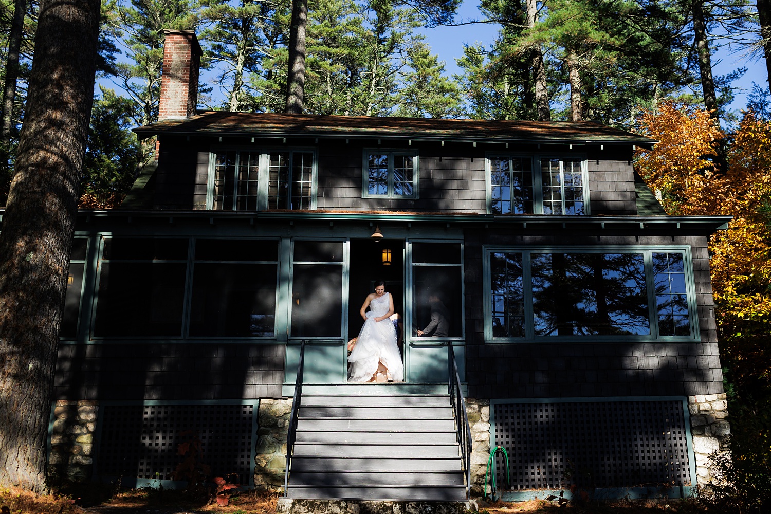 THe bride comes out of her cabin at Migis Lodge in Maine to finish getting into her dress