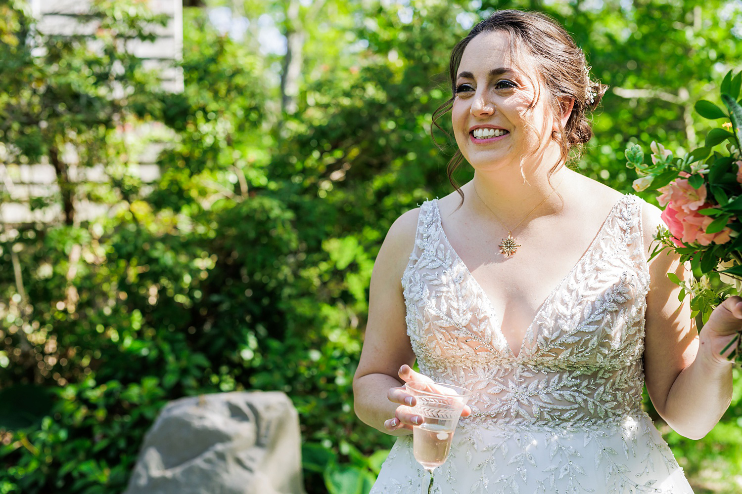 Bride smiles with a glass of wine at her family home on Cape Elizabeth Maine