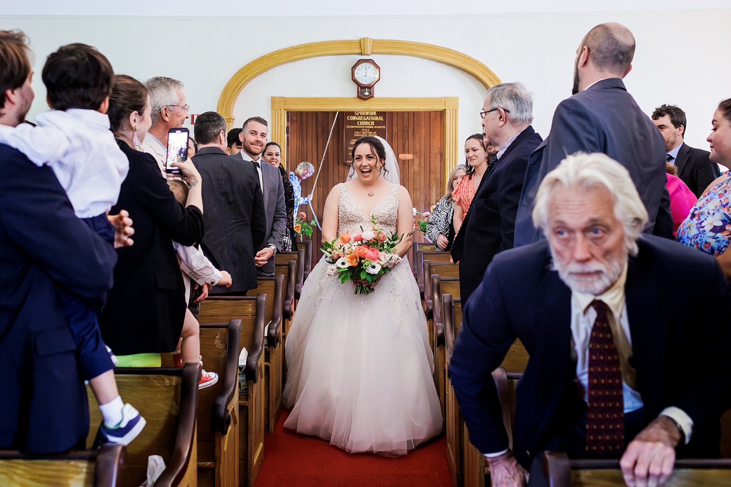 Bride grins from ear to ear as she enters the wedding chapel in Cape Elizabeth