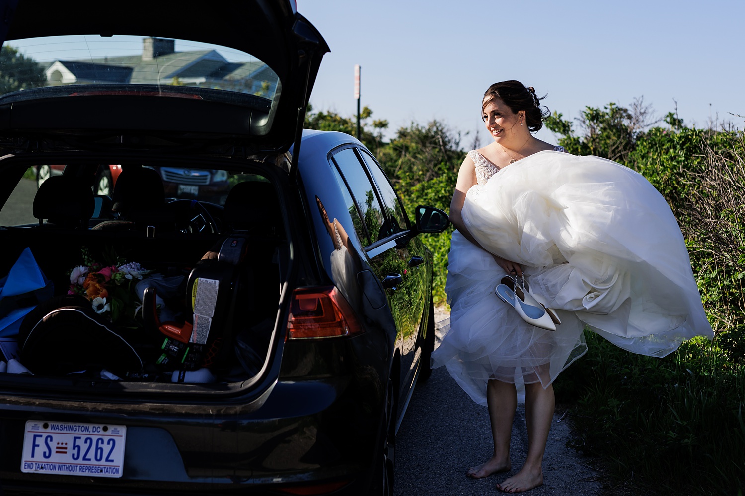 Bride awaits help to get into the car after her Cape Elizabeth Maine wedding day