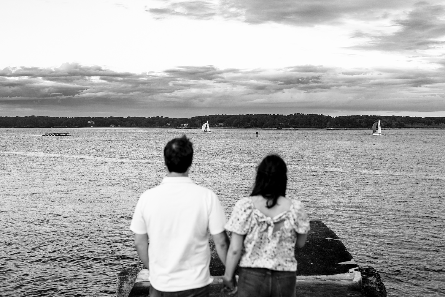The couple walks out by the water at Great Island Common in NH