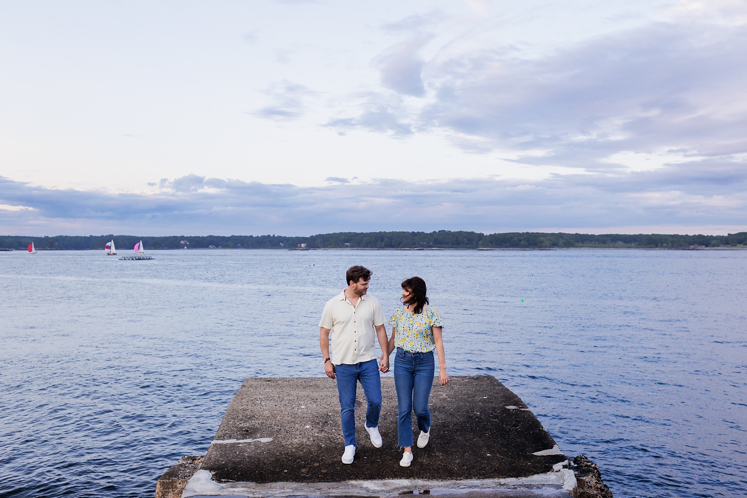 The couple walks out by the water at Great Island Common in NH