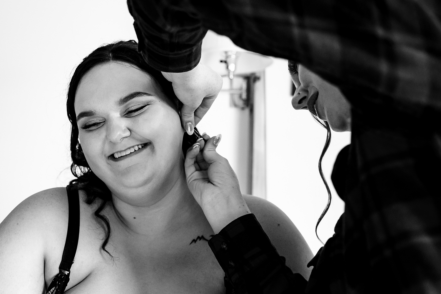 Maid of honor helping the bride with her piercing