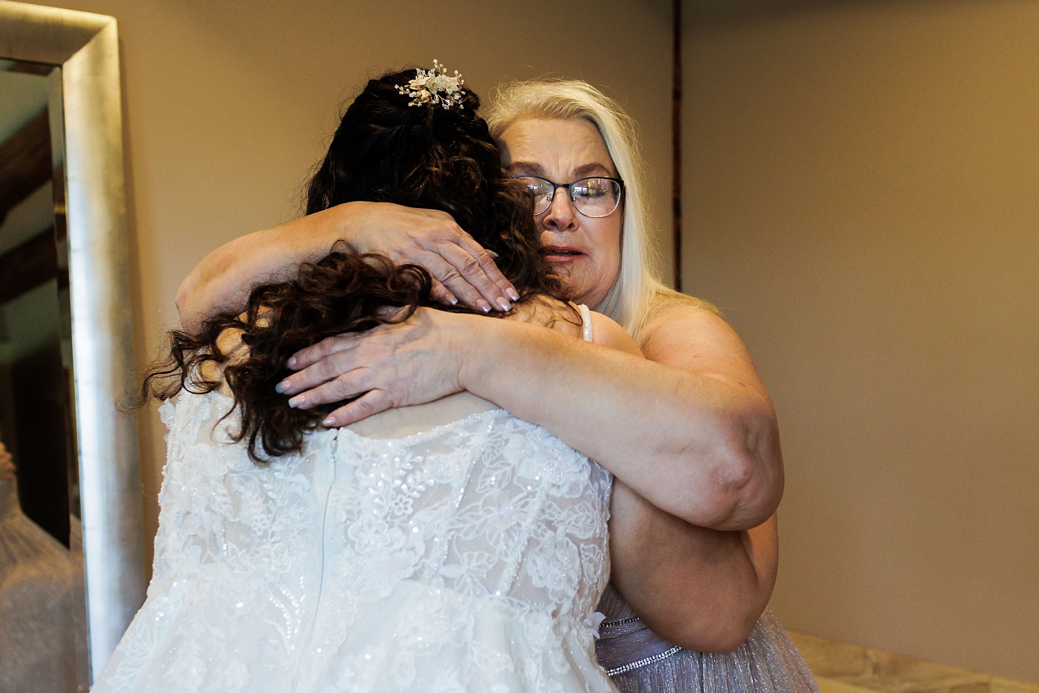 Mother of the bride tears up as she hugs her daughter on her wedding day