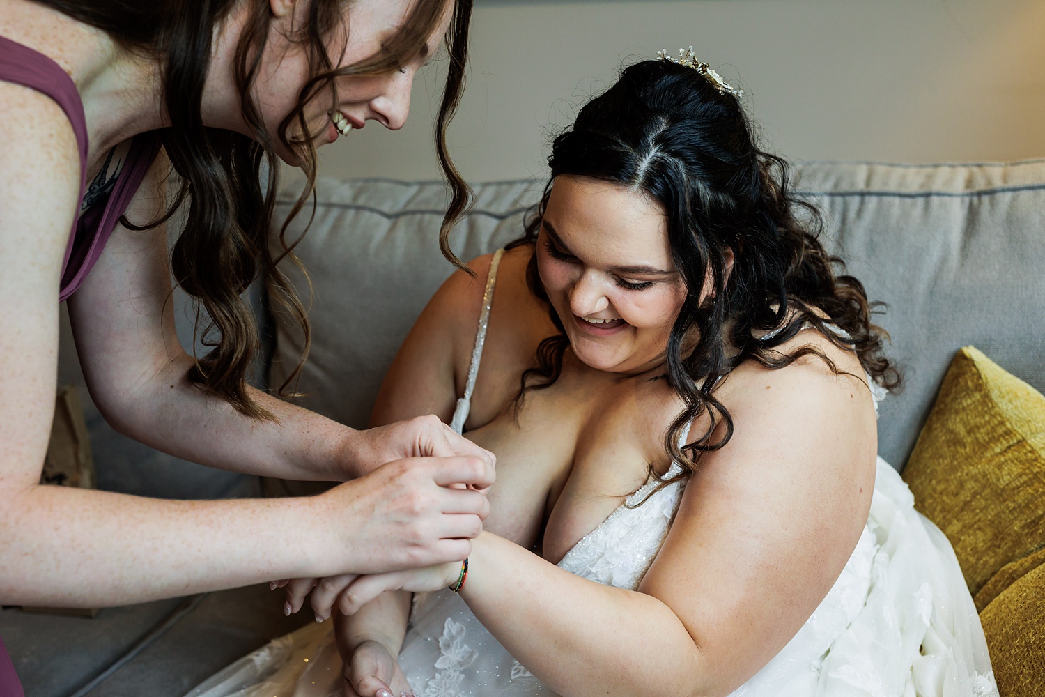 Maid of Honor helps the bride get a bracelet on from the groom