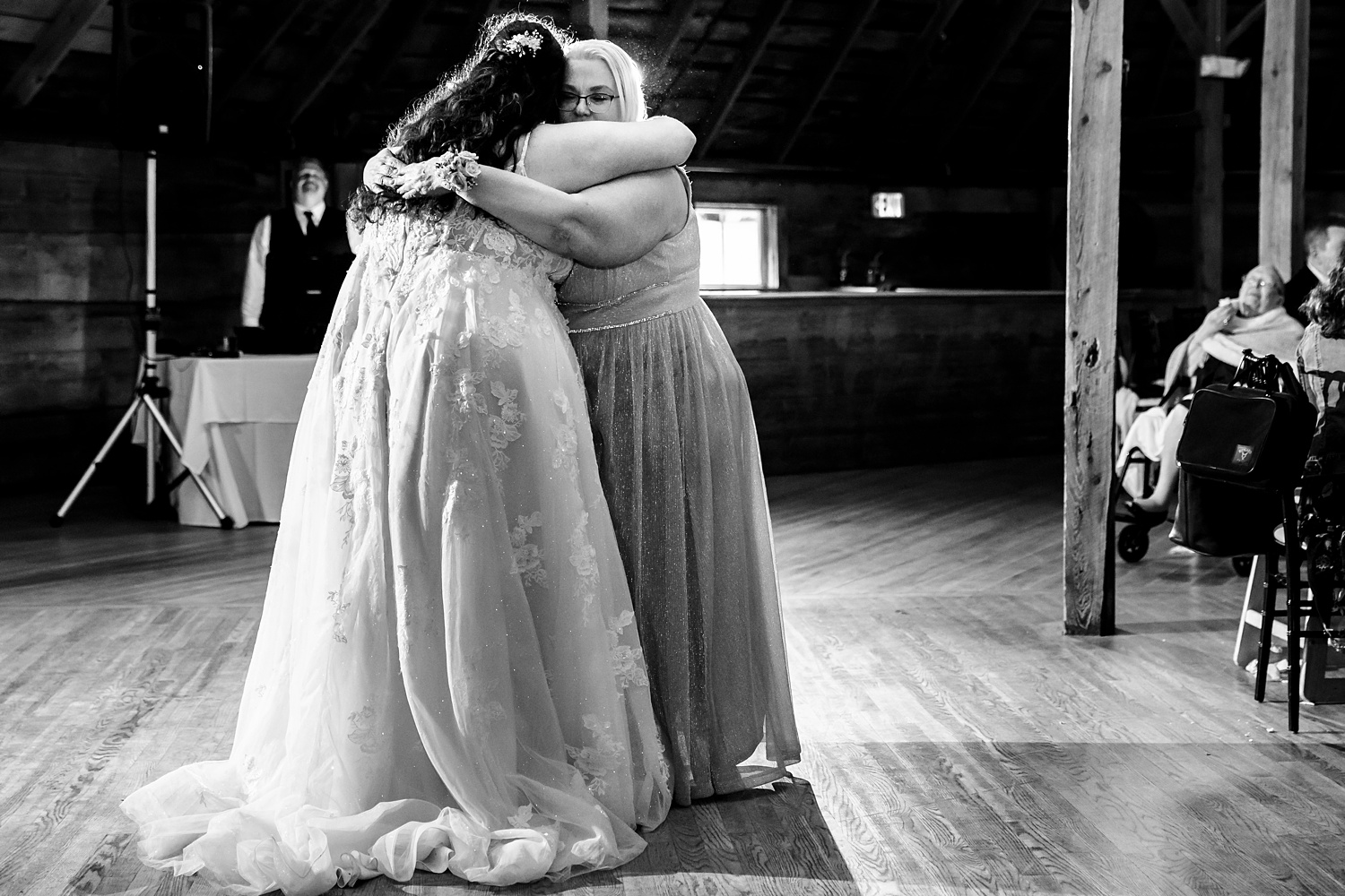 The bride and her mom share a hug on the dance floor