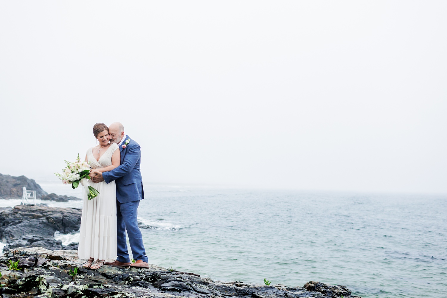 A snuggle on the cliffs overlooking the views on Marginal Way Maine for the couple who eloped