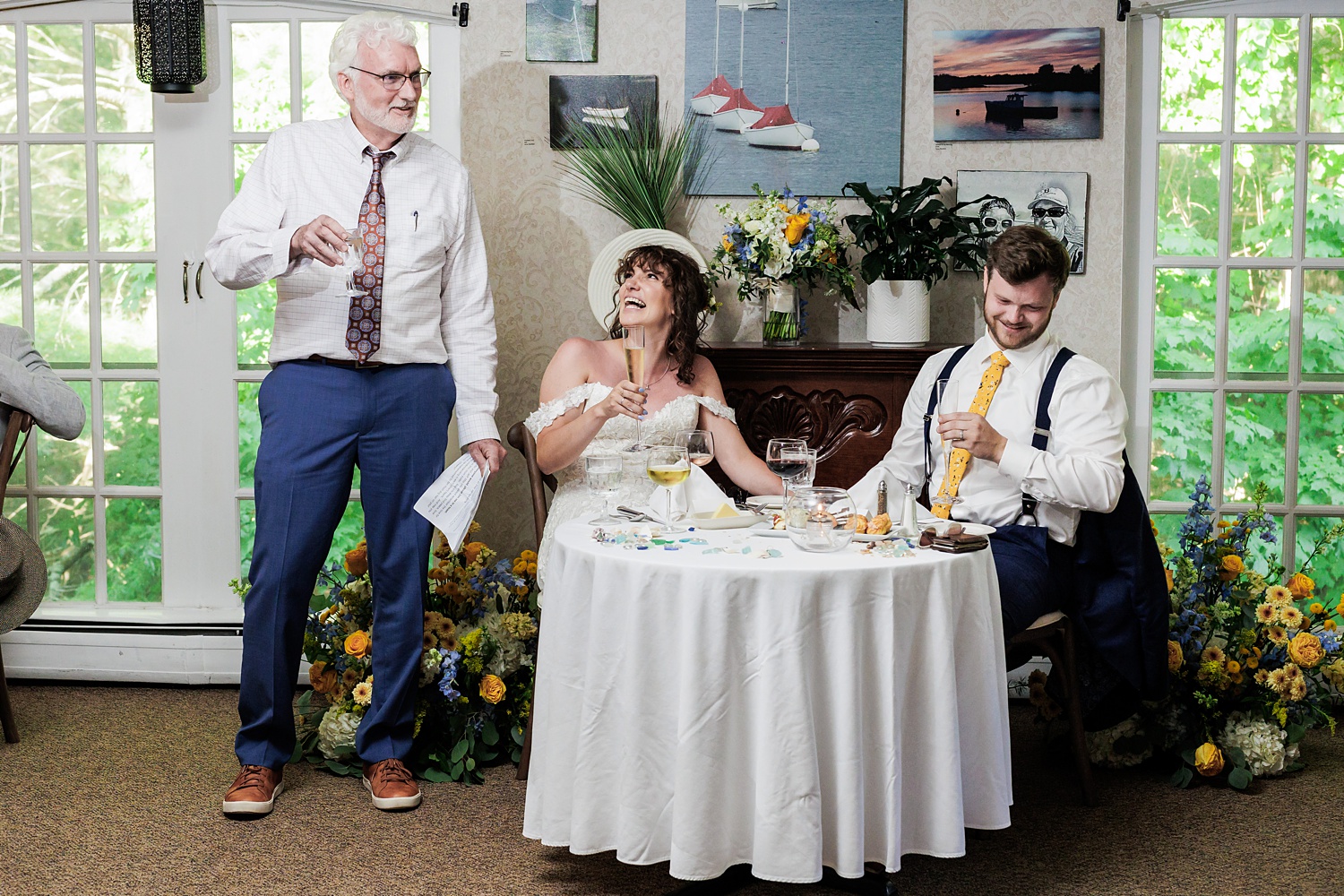 The couple listen to toasts on their wedding day